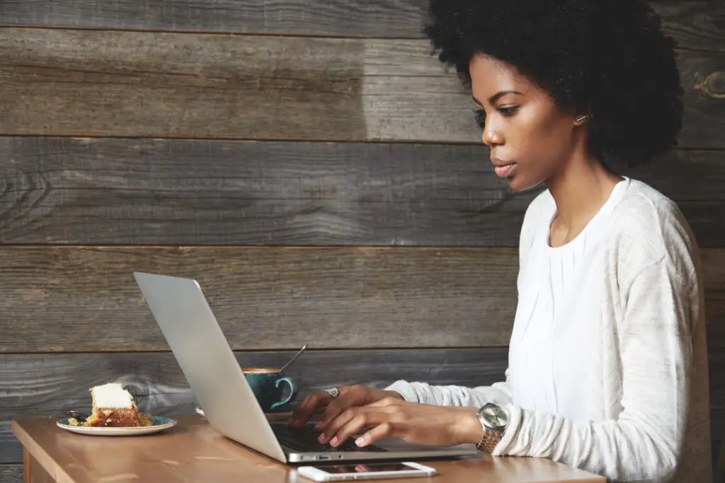 Black Woman sitting at her Laptop. The Enlightened Creative