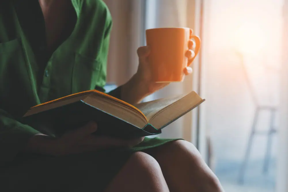 Woman Reading Book and Drinking Coffee. The Enlightened Creative.