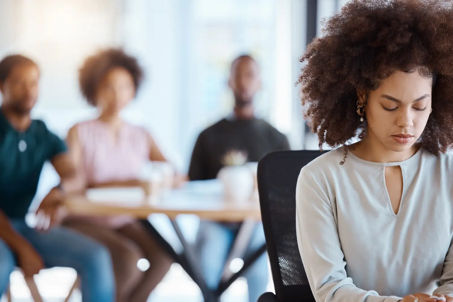 Workplace bullying, anxiety and gossip of businesswoman with depression, mental health and sad victim exclusion by employees in company office. Lonely, depressed and harassment worker discrimination